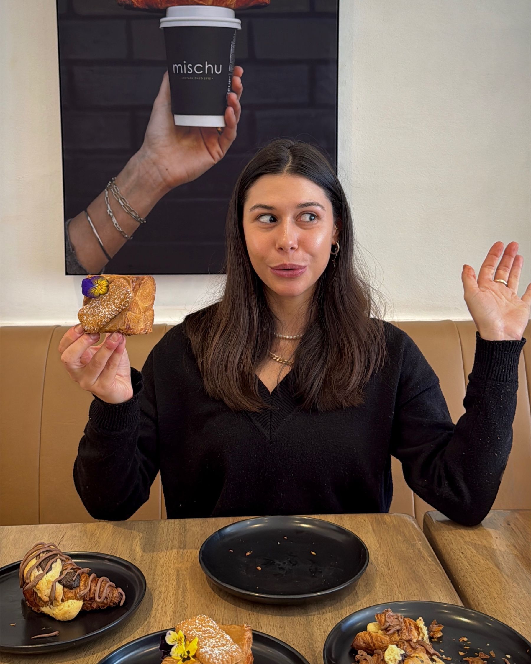 Paige holding a Biscoff Cube and about to take a bite at Mischu in Sea Point.