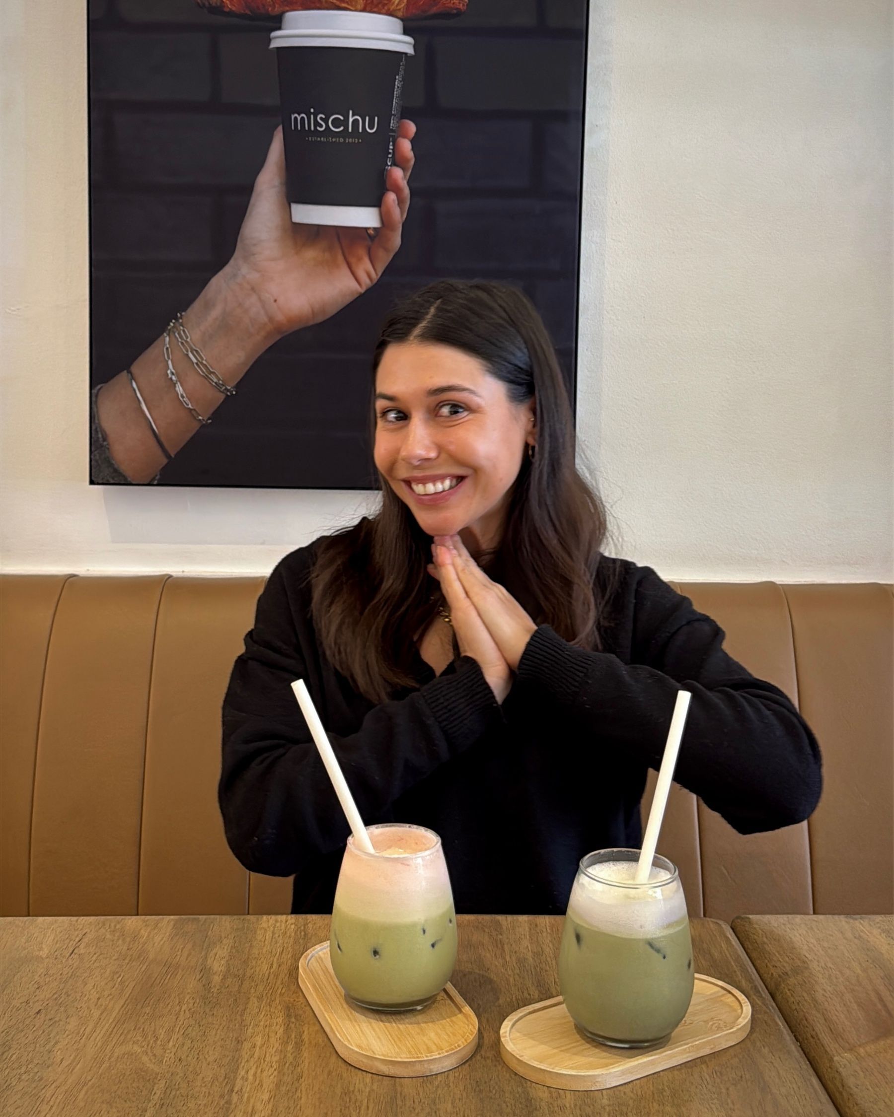 Paige smiling at the table with two colourful iced matchas at Mischu.