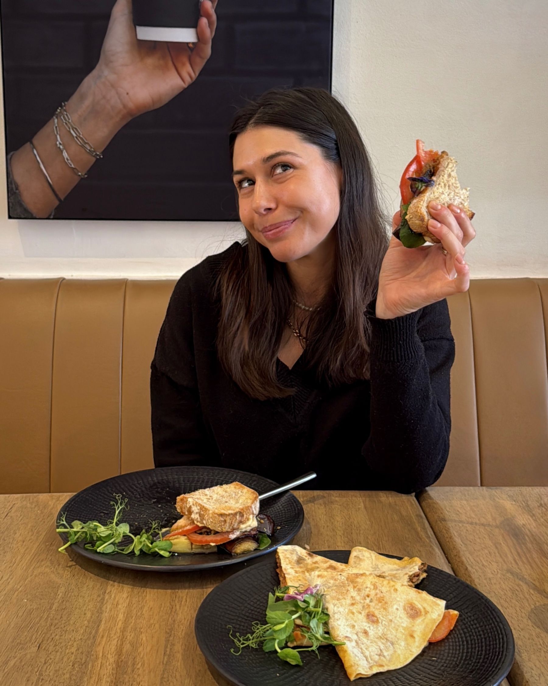 Paige eating the Mediterranean Sourdough Sandwich at Mischu.