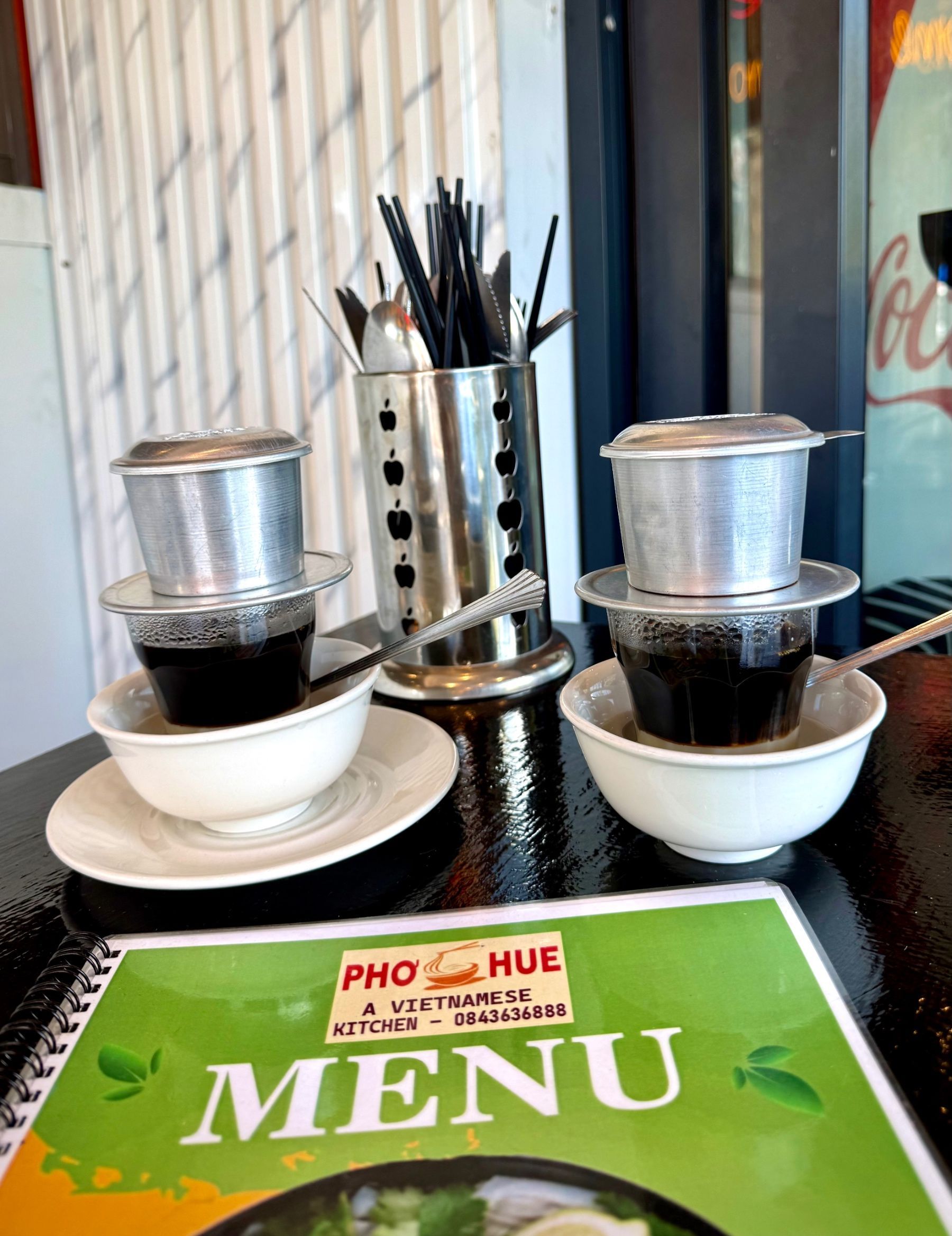 Traditional Vietnamese coffee slowly brewing through a phin filter at Pho Hue in Hout Bay.