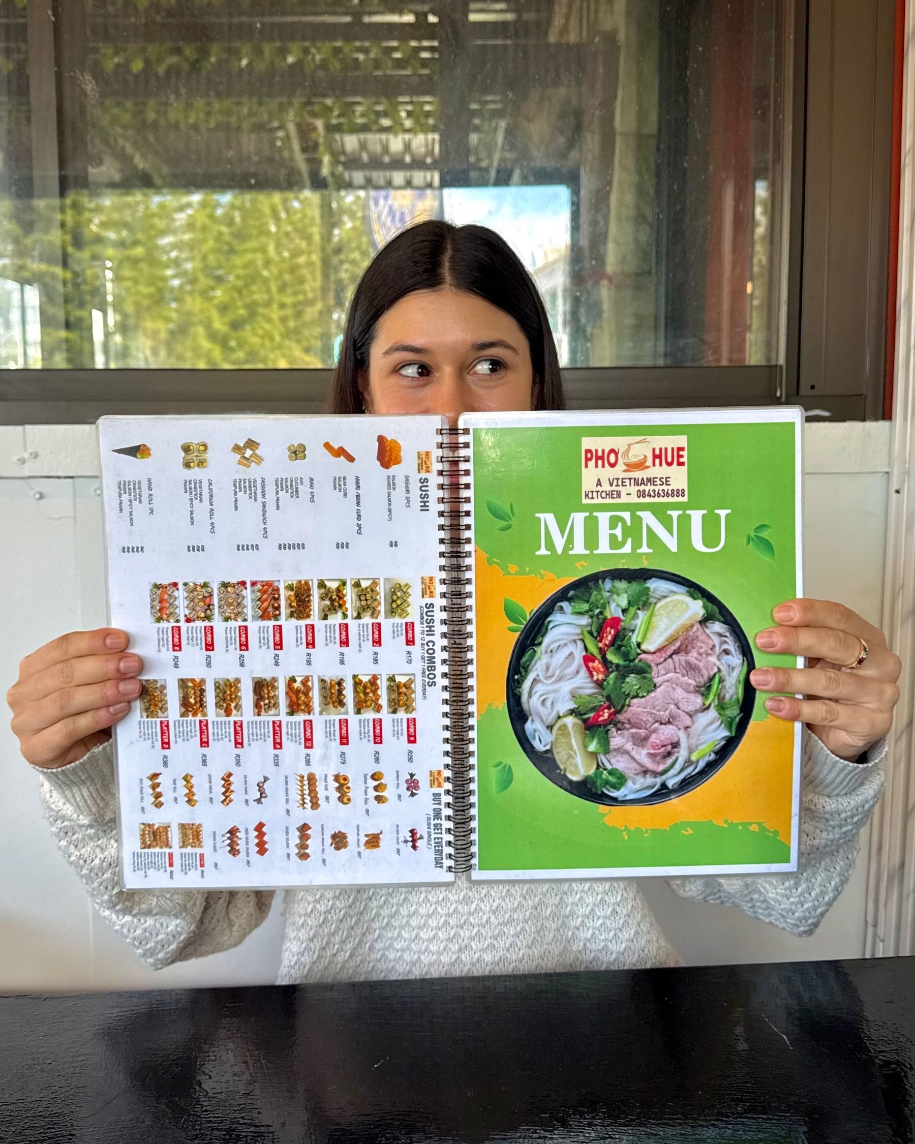 Paige holding the menu at Pho Hue while deciding what to order.