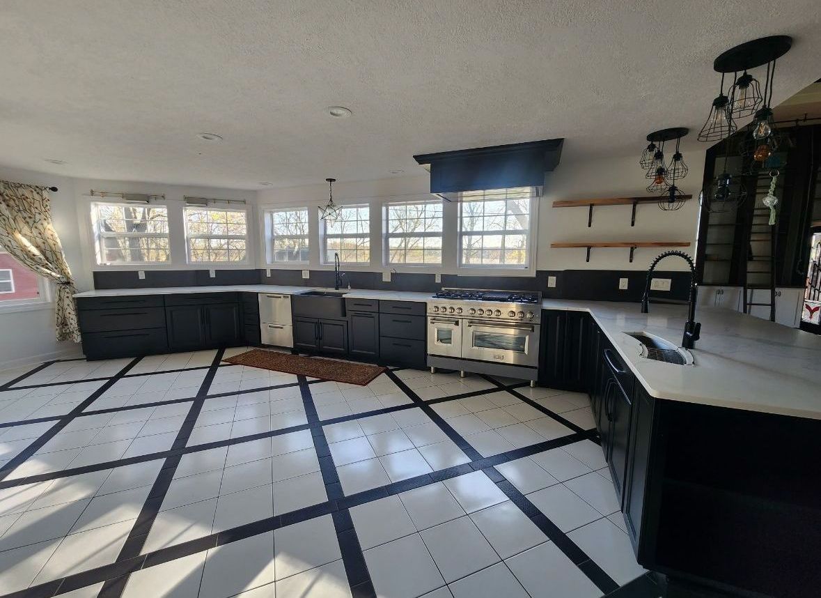 A kitchen with black cabinets and white counter tops