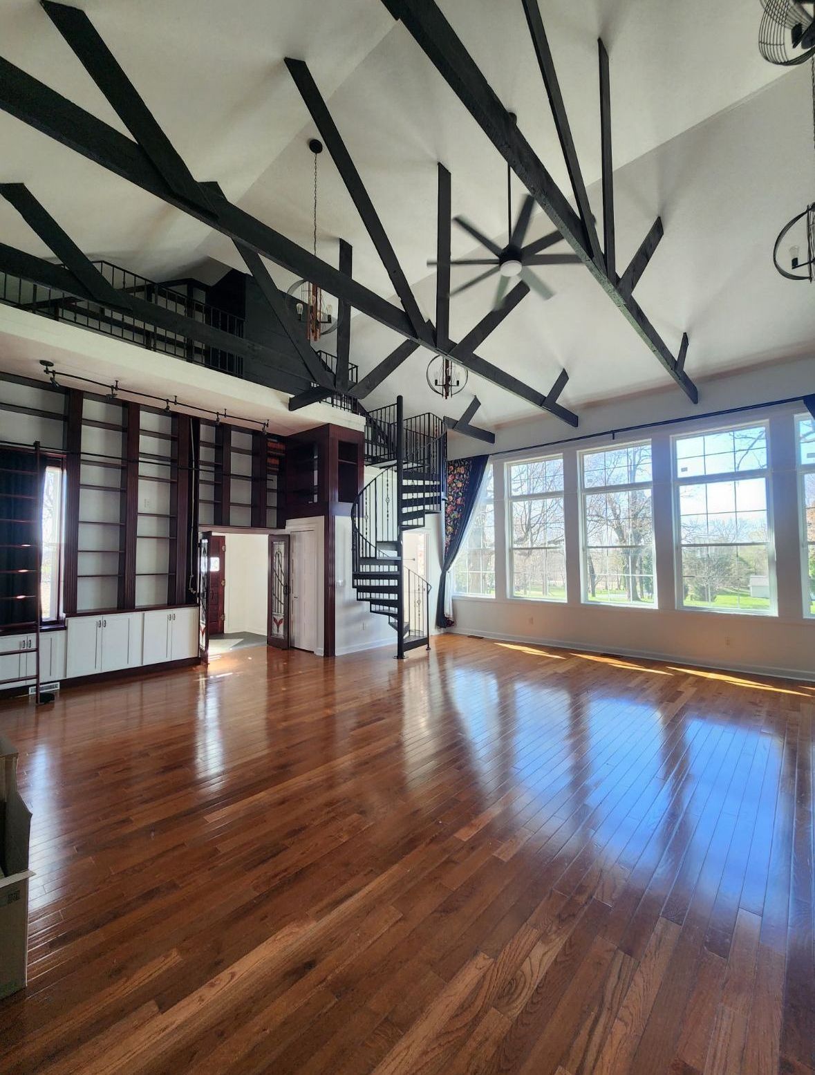A large room with hardwood floors and a spiral staircase