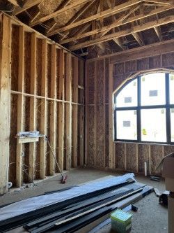 A room in a house under construction with a large window.