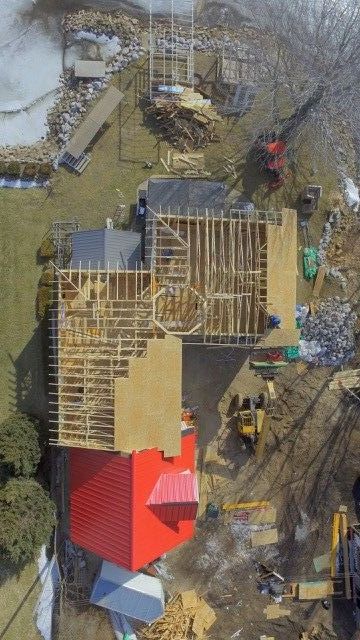 An aerial view of a house under construction with a red roof