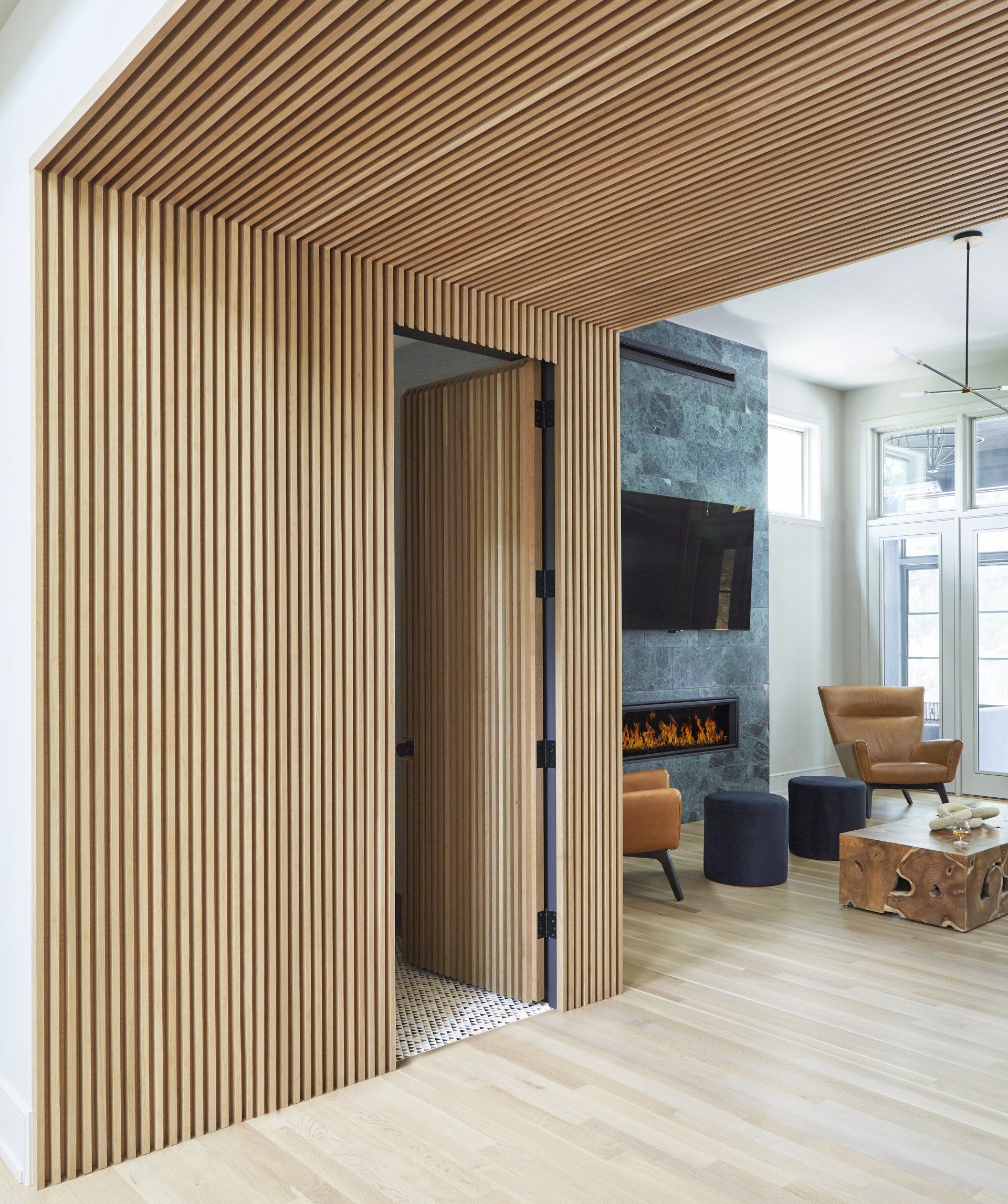 A living room with a wooden wall and a fireplace.