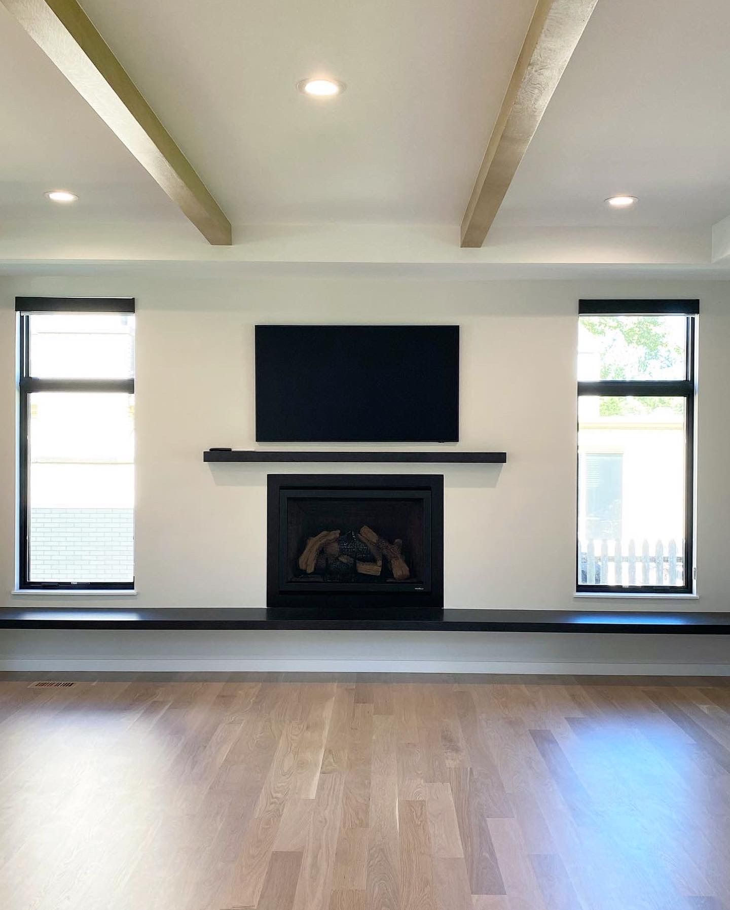A living room with a fireplace and a flat screen tv on the wall.