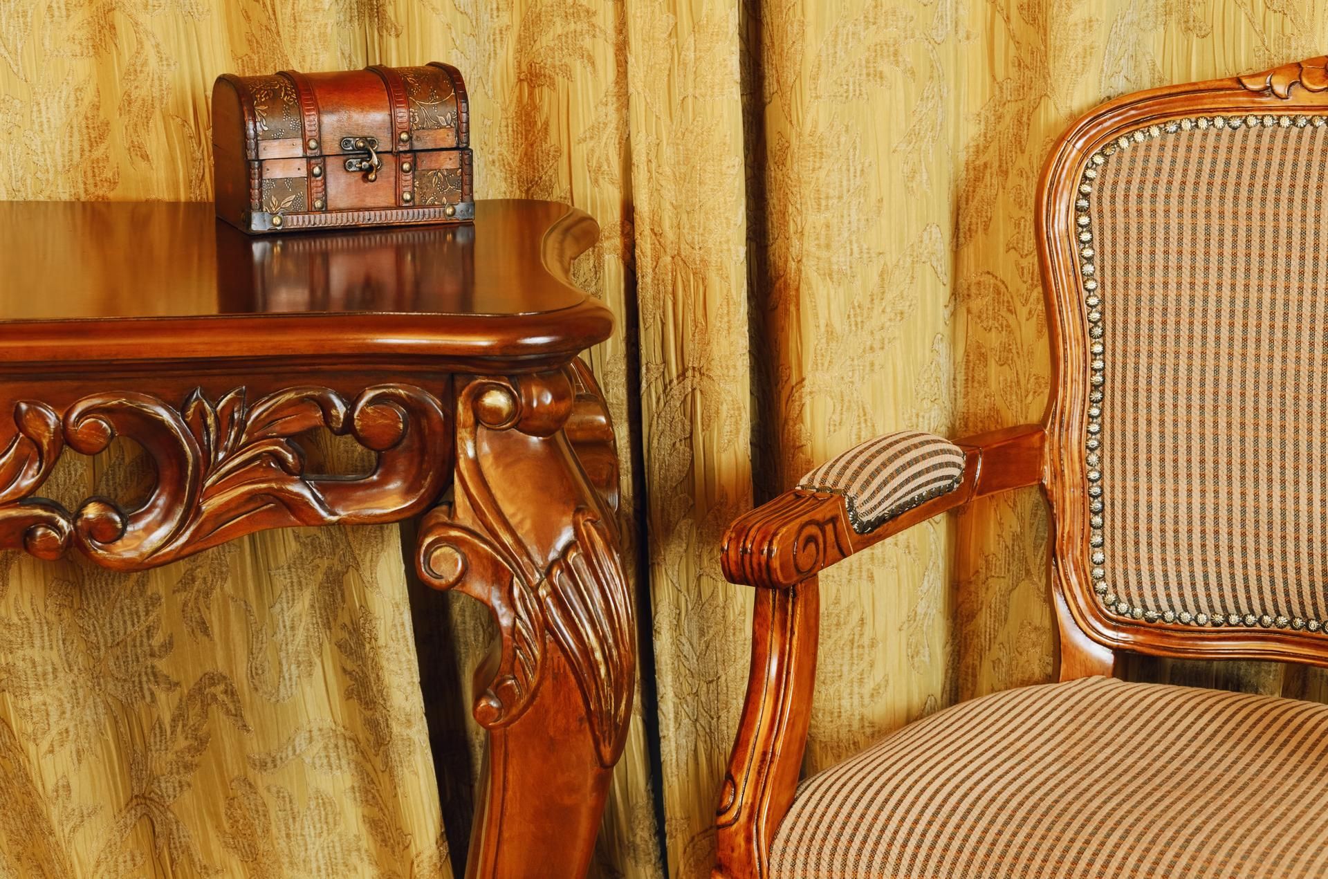 A wooden table with a trunk on top of it next to a chair.