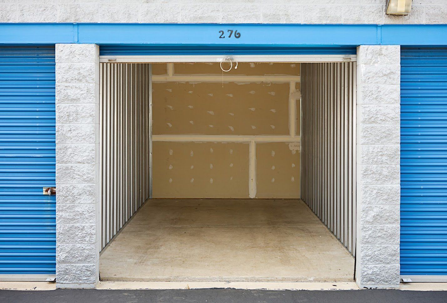 An empty storage unit with the number 27b on the door