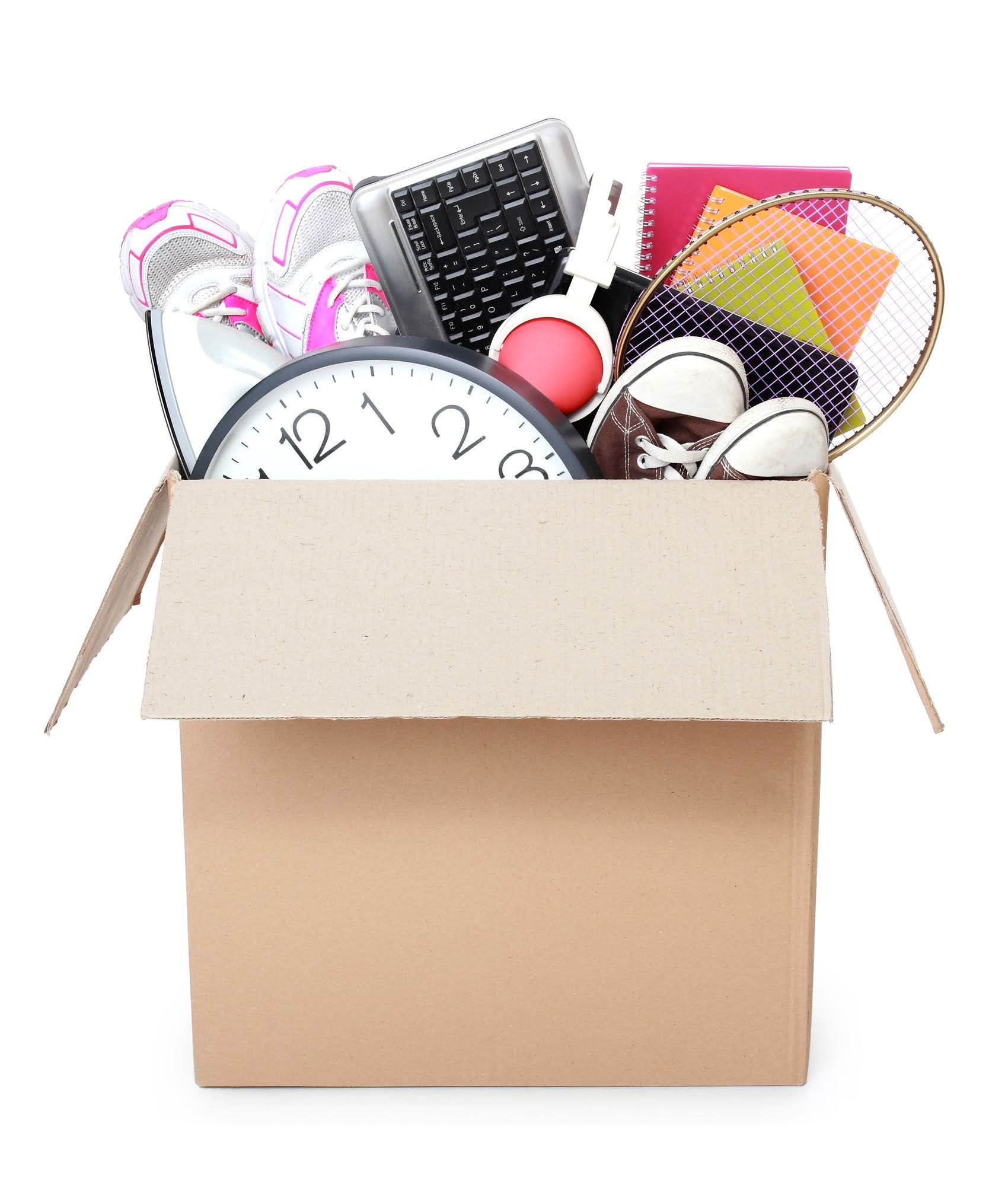 A cardboard box filled with a variety of items including a clock and a keyboard.