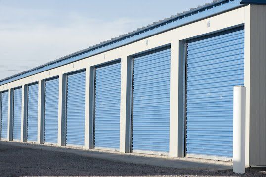 A row of blue garage doors on a building