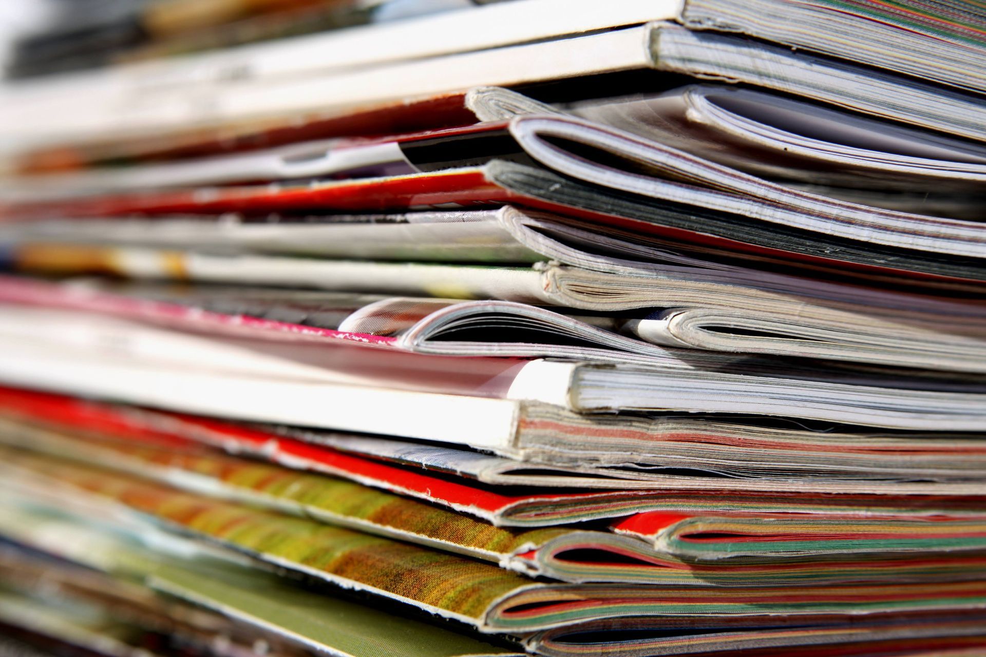 A close up of a stack of magazines on a table.