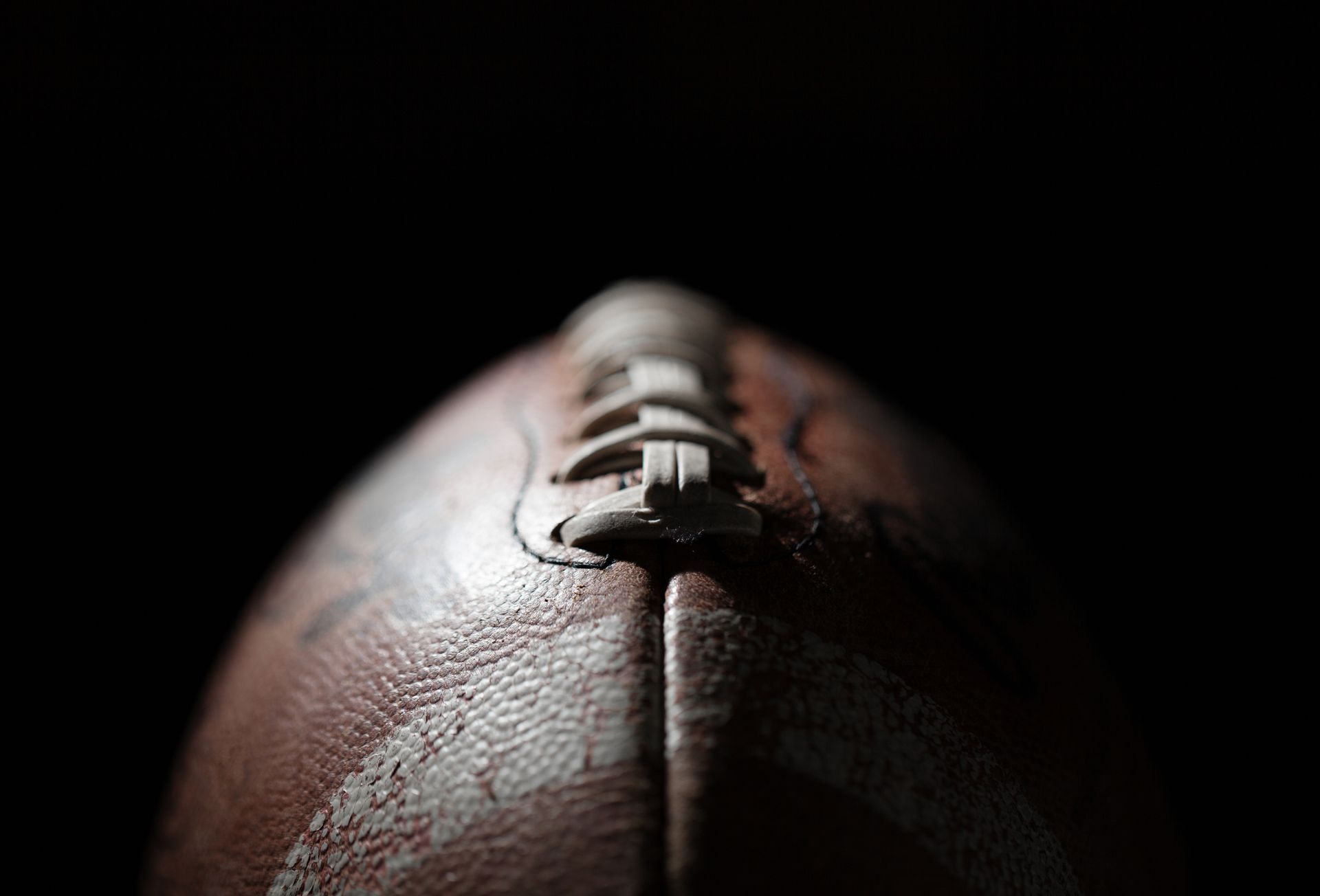 A close up of a football on a black background.