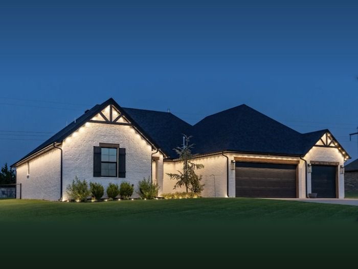 Home with warm white permanent LED lighting installed along the roofline at night