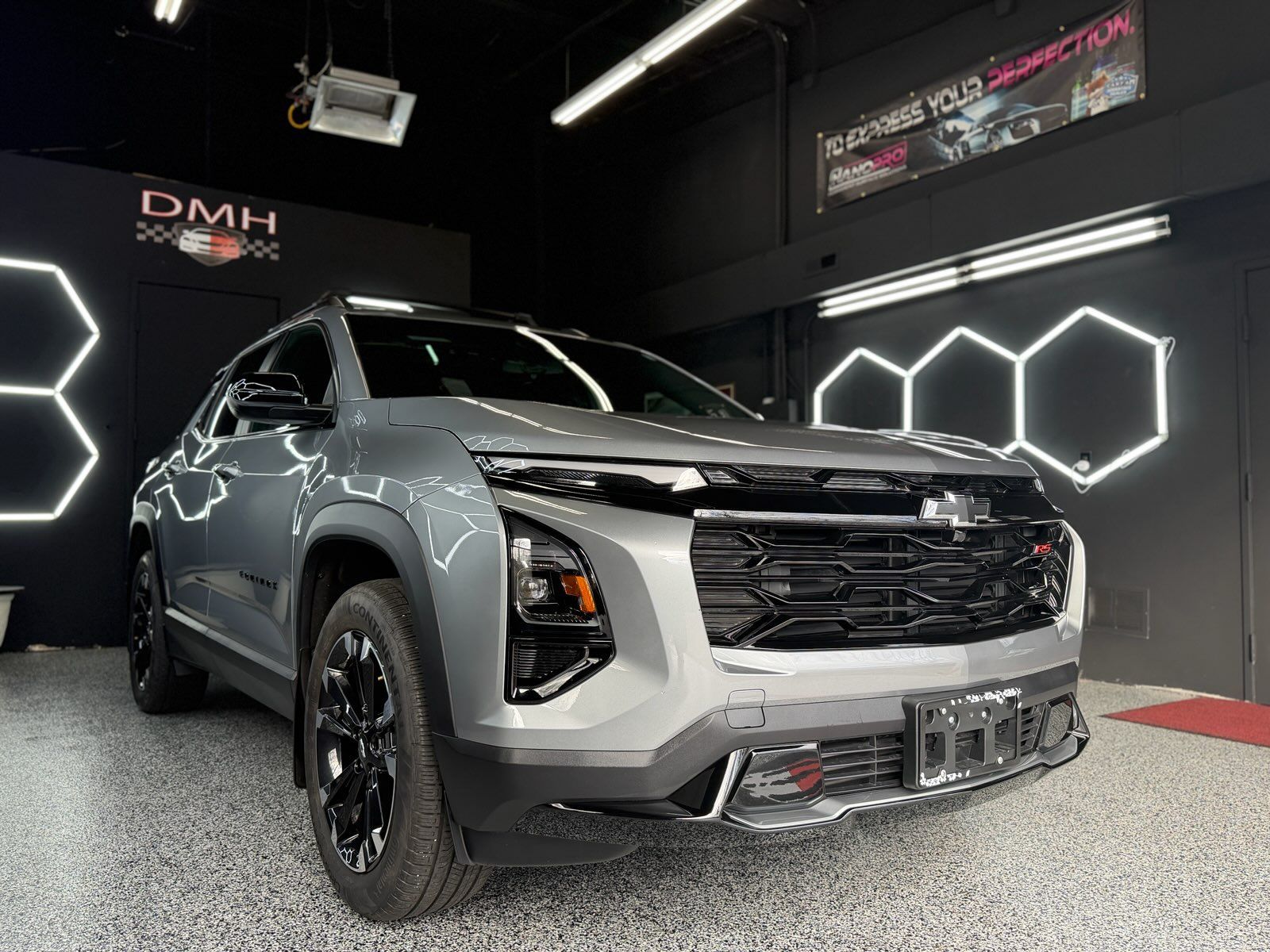 Gray SUV displayed in a studio with geometric neon wall lights