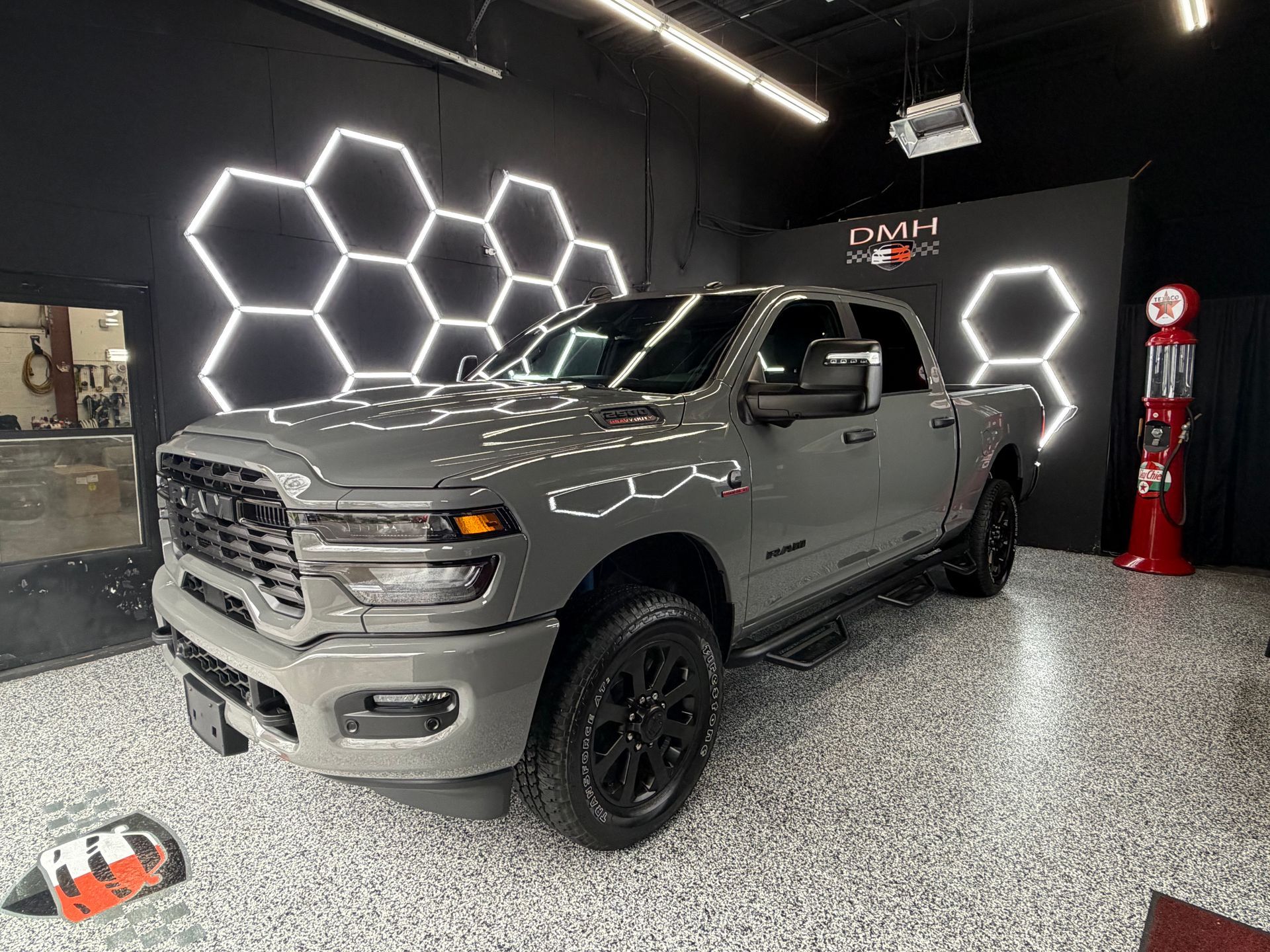 Gray pickup truck in a showroom with hexagonal LED wall lights and polished speckled floor