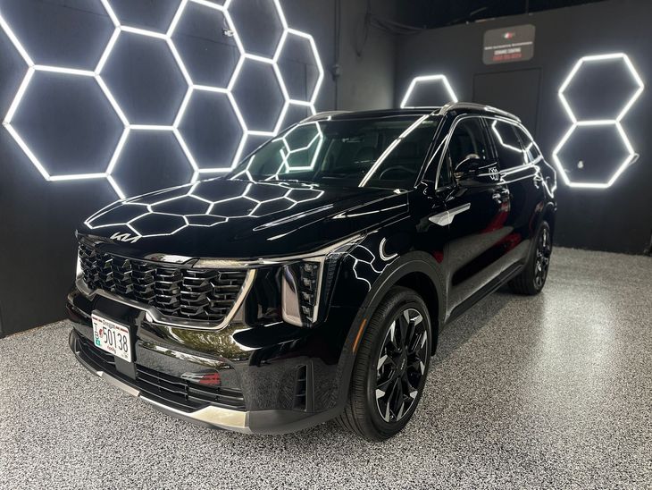 Black SUV in a showroom with glowing hexagonal wall lights