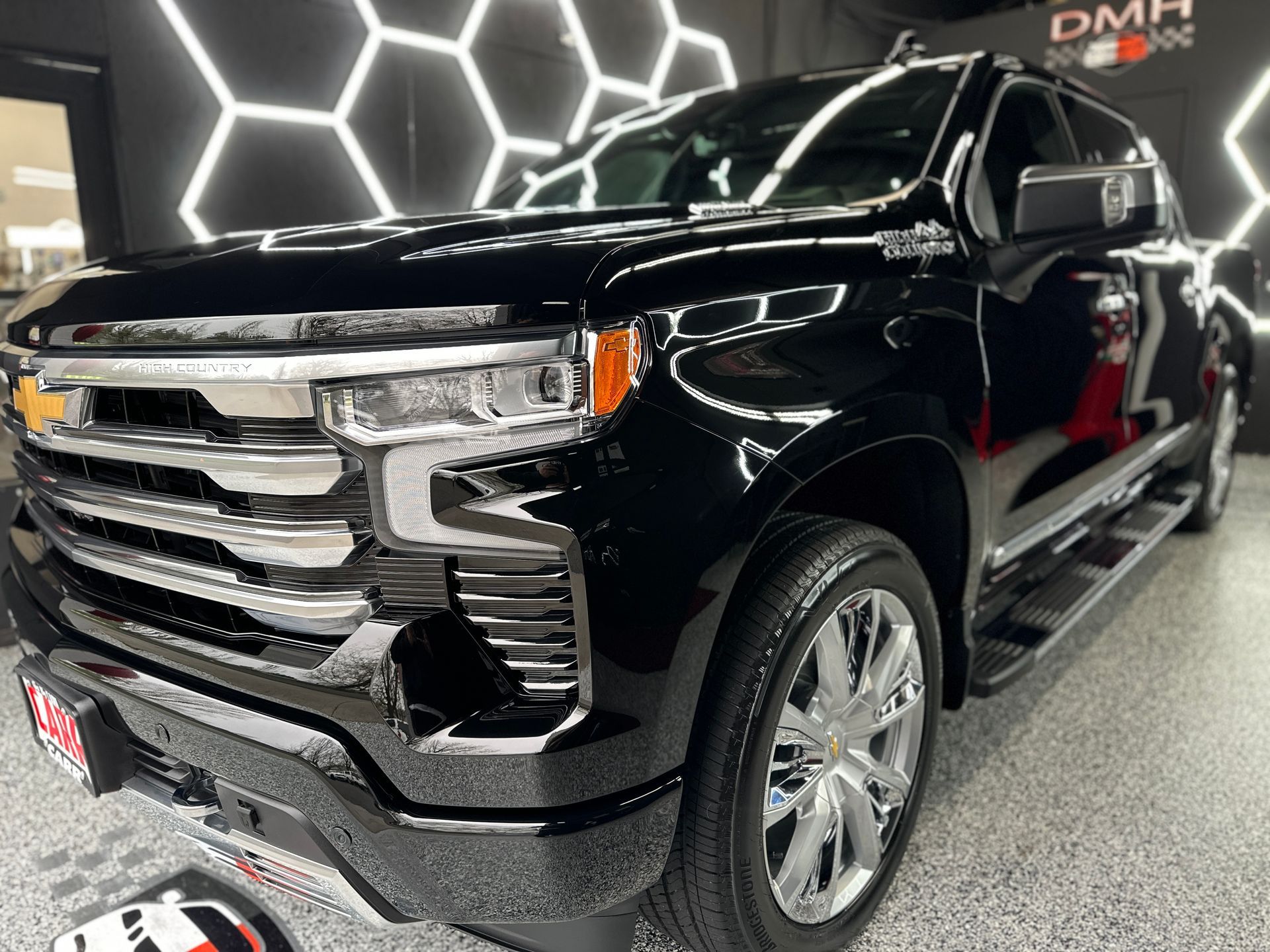 Black pickup truck in a showroom with hexagonal wall lighting
