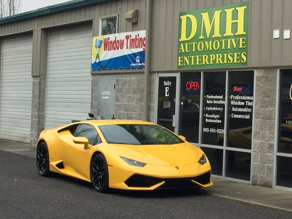 Yellow sports car parked outside DMH Automotive Enterprises storefront