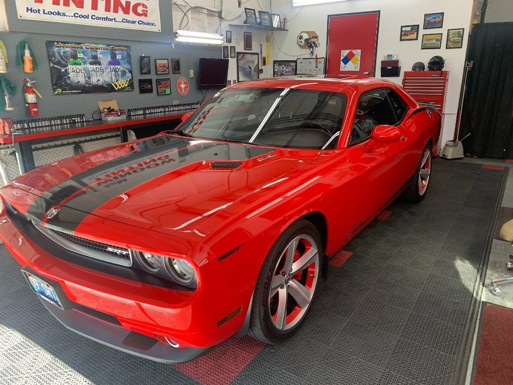 Red classic muscle car in a garage, viewed from the front-left side