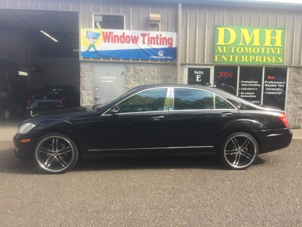 Black coupe parked in front of Window Tinting and DMI Automotive Enterprises shops