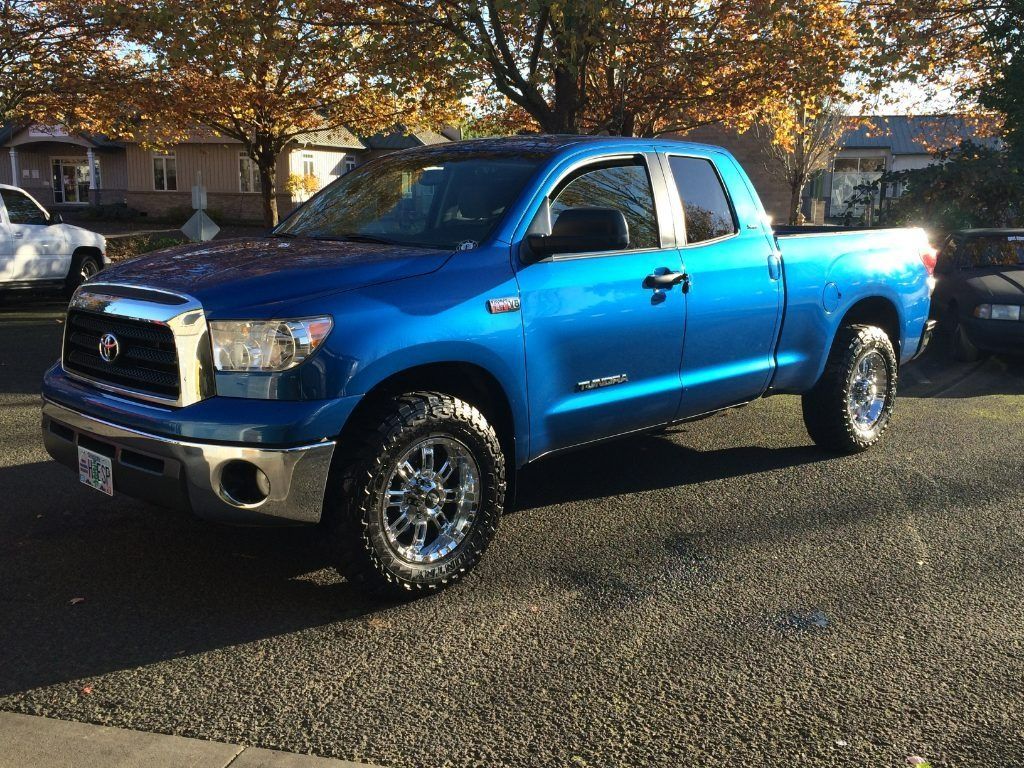 Blue Toyota pickup truck parked on a street in autumn light
