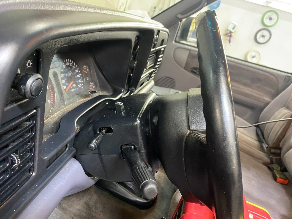 Damaged car interior with a broken steering wheel and dashboard in a light-colored vehicle