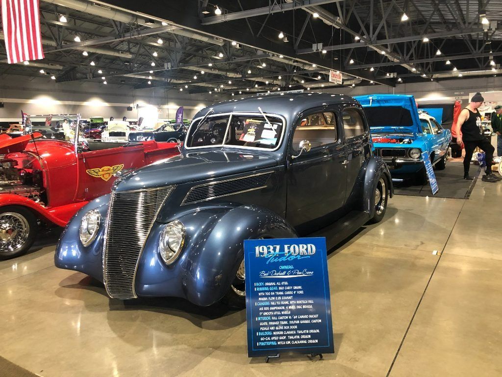 Classic navy blue 1937 Mercury at indoor car show, with a blue info sign in front