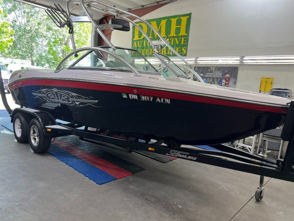 Black-and-red speedboat on trailer inside a dealership showroom