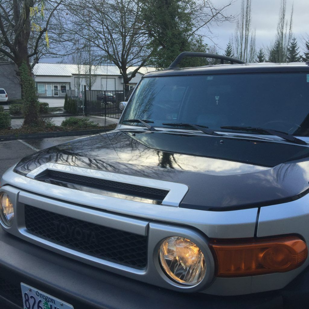 Front view of a black SUV with silver trim parked outdoors at dusk