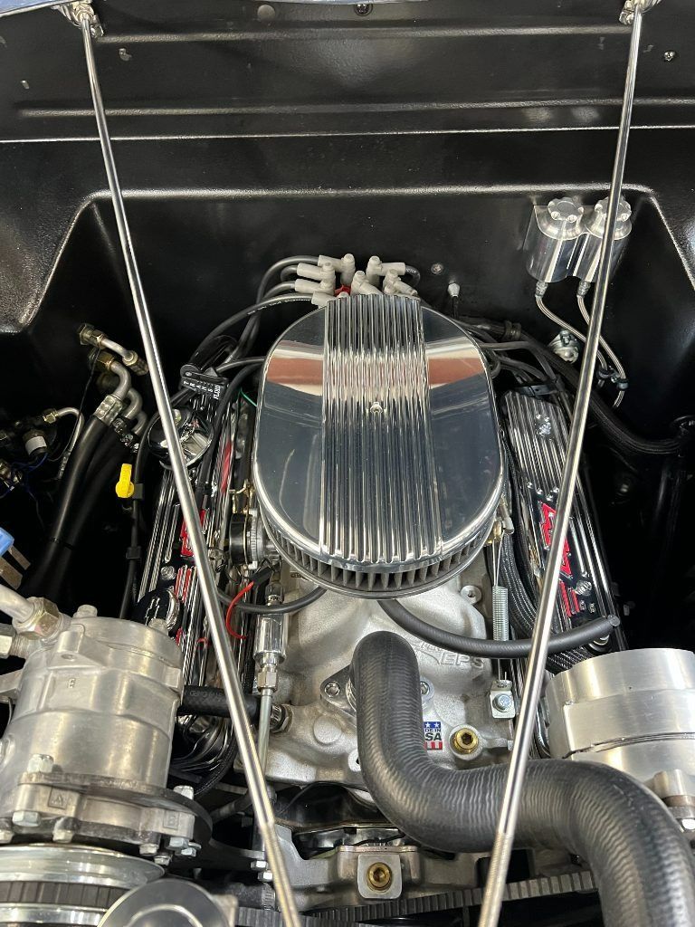 Engine bay with chrome air filter, polished hoses, and black components under an open hood