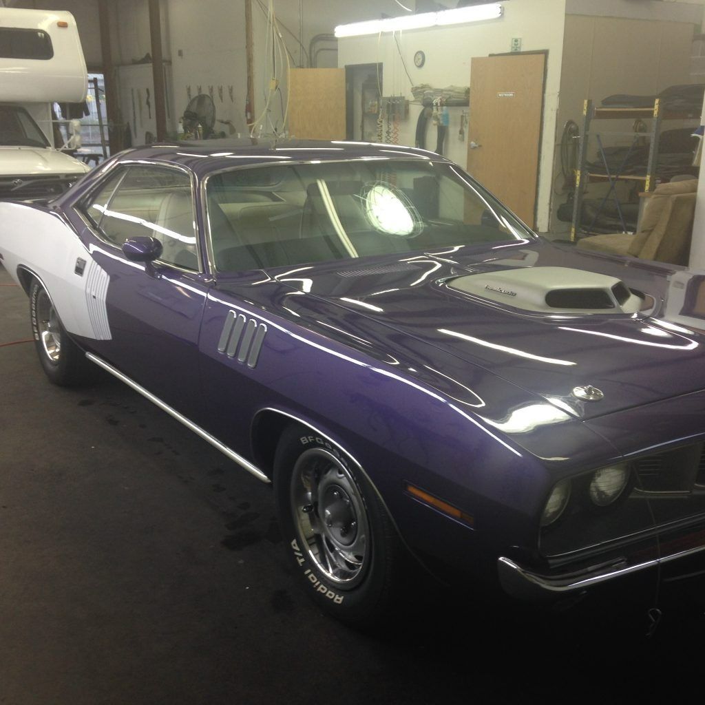 Purple classic muscle car in a garage, shown from the front-left side.