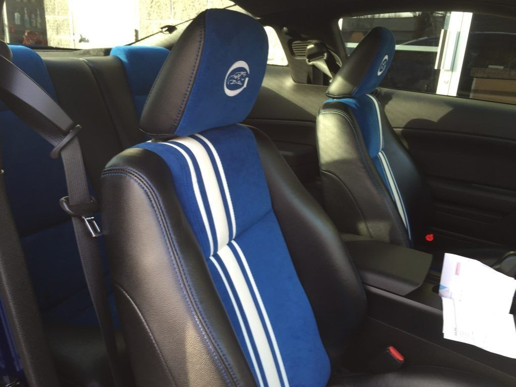 Blue and black bucket seats with striped headrest covers inside a car interior