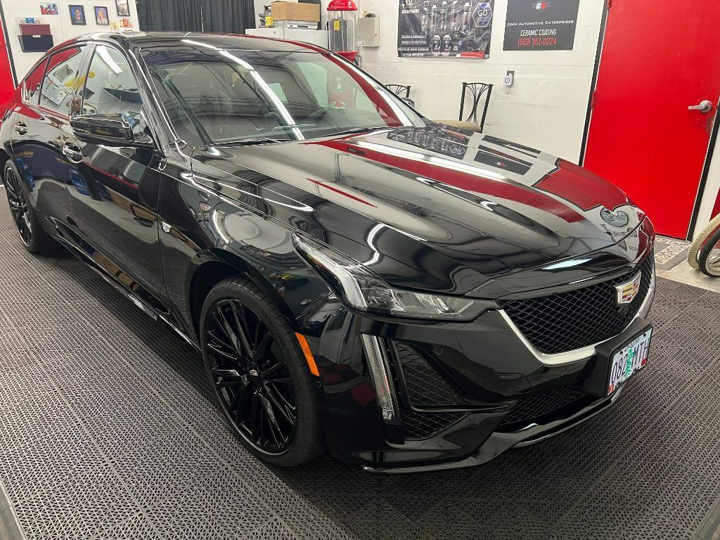 Black SUV in a showroom, angled front view with glossy paint and red accents