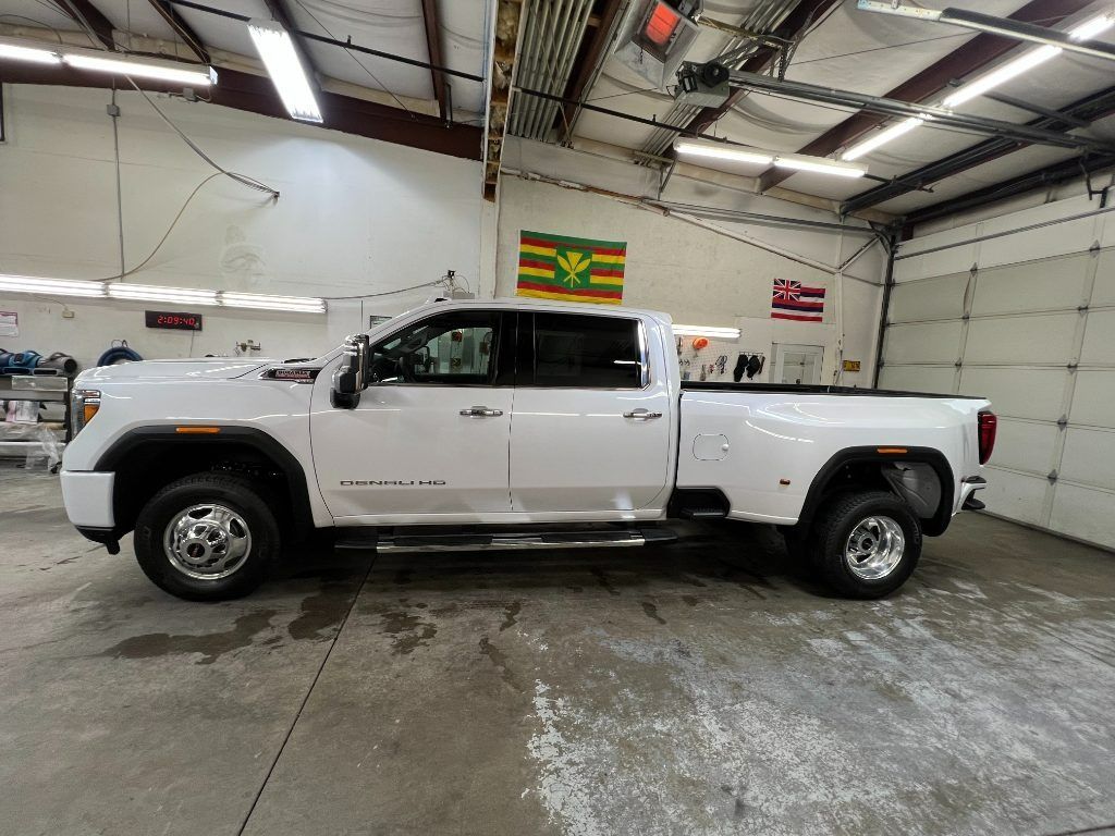 White crew-cab pickup truck in a garage, side view on a concrete floor