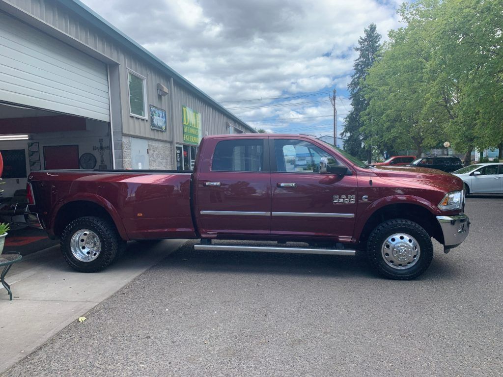 Maroon pickup truck parked in a driveway beside a garage on a residential street.