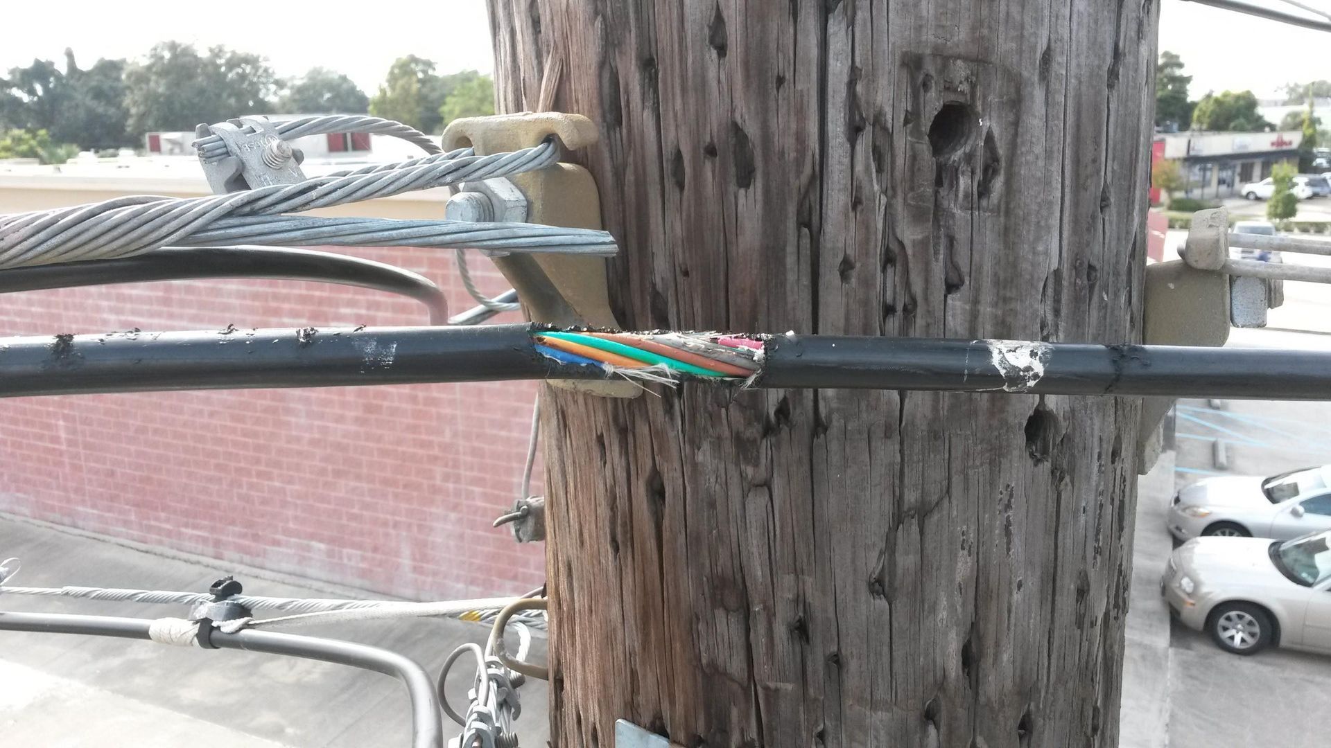 A telephone pole with a bunch of wires attached to it