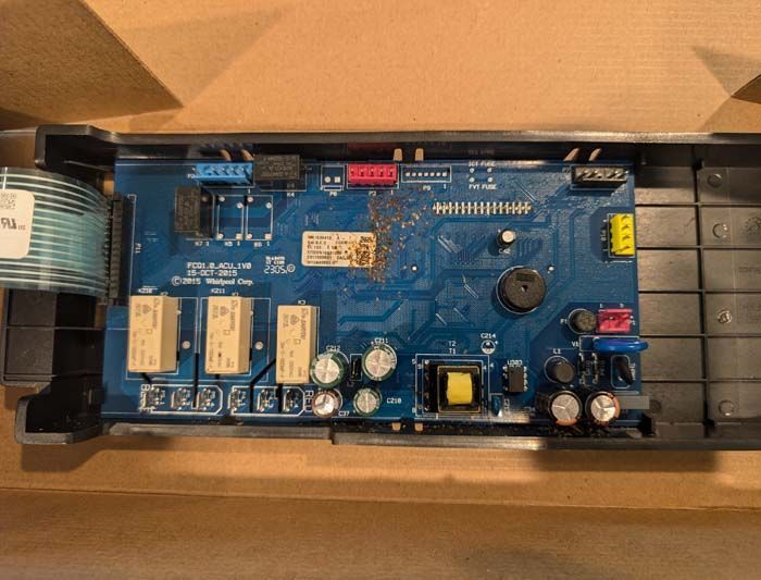 Blue circuit board with several components inside a black enclosure.
