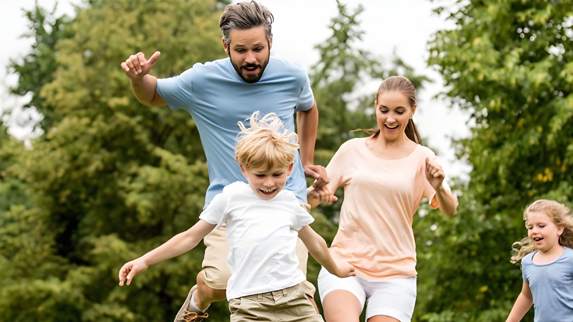 A family is running in a park holding hands — Coast & Country Insurance Consultants Pty Ltd In Central Coast, NSW