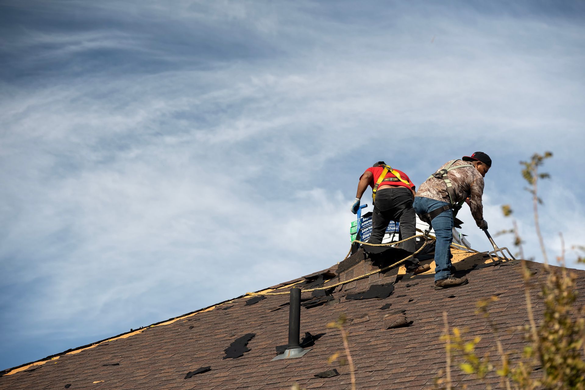 Two roofers working on a residential roof.