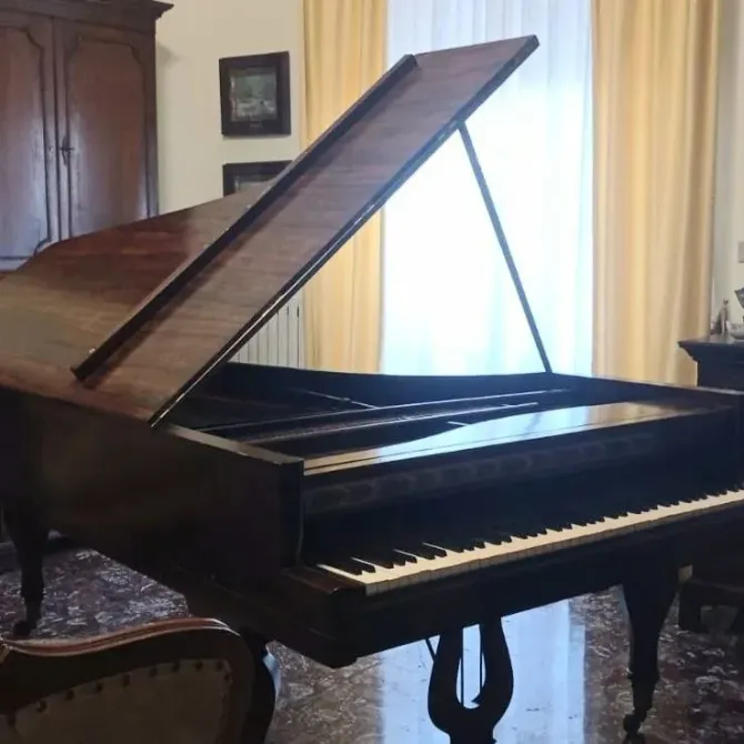un pianoforte a coda in un soggiorno con la tastiera aperta