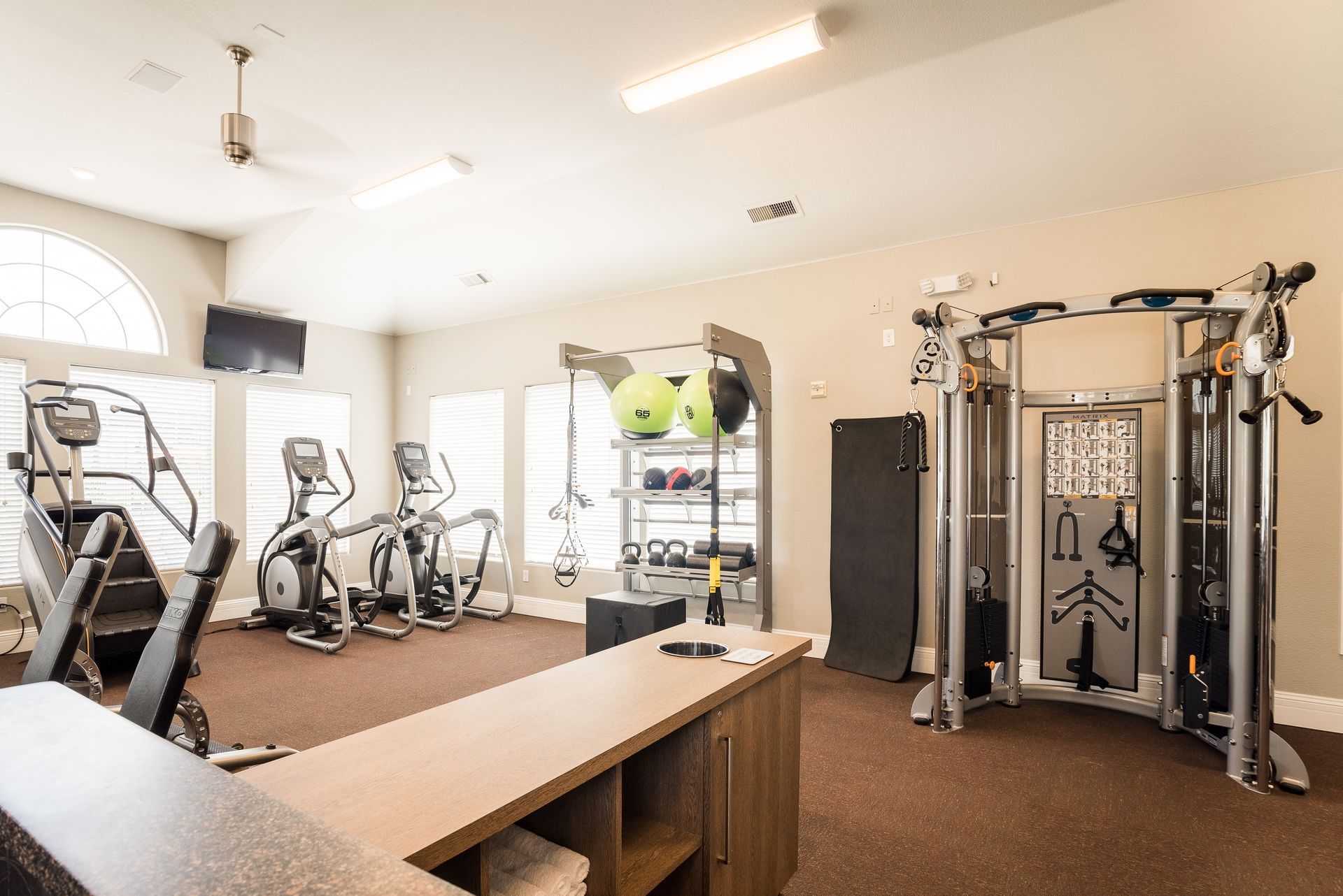 Gym with cardio machines, weights, and cable machine.