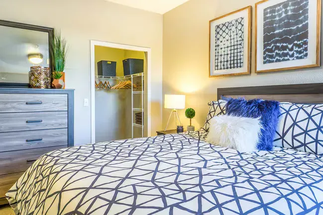Bedroom with a bed, dresser, closet, art, and various decorations.
