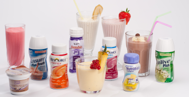 Diverse voedzame dranken en shakes in glazen en flessen, met fruitgarnituur.