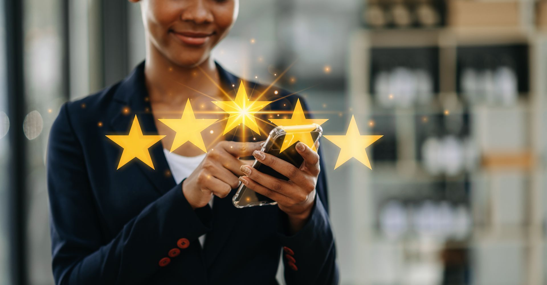A woman is holding a cell phone with three stars coming out of it.