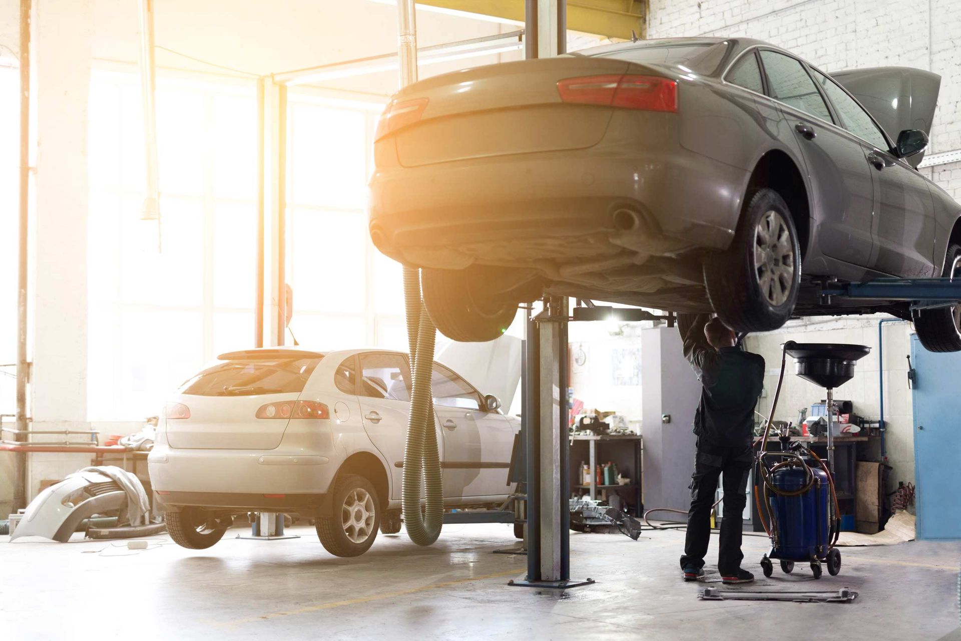 Cars Being Serviced On Lifts In A Bright Auto Repair Garage — KBX Mechanical In West Mackay, QLD