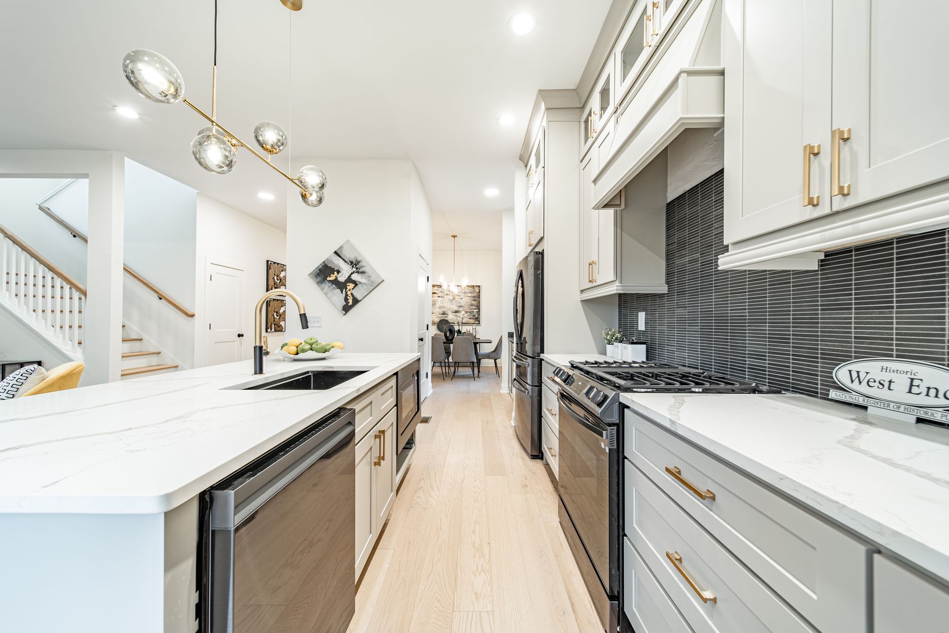 Modern kitchen with gray cabinets, white countertops, and stainless steel appliances.