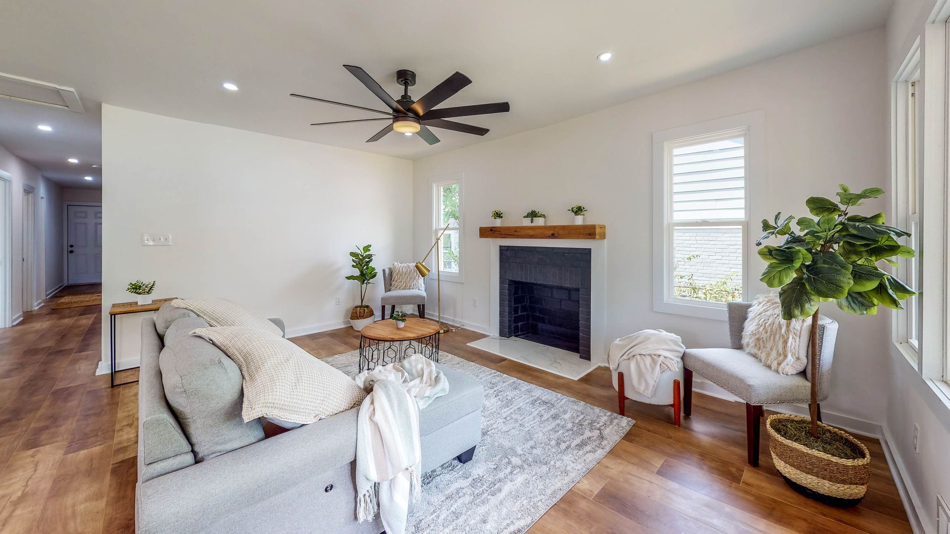 Living room with wood floors, fireplace, and gray sofa.