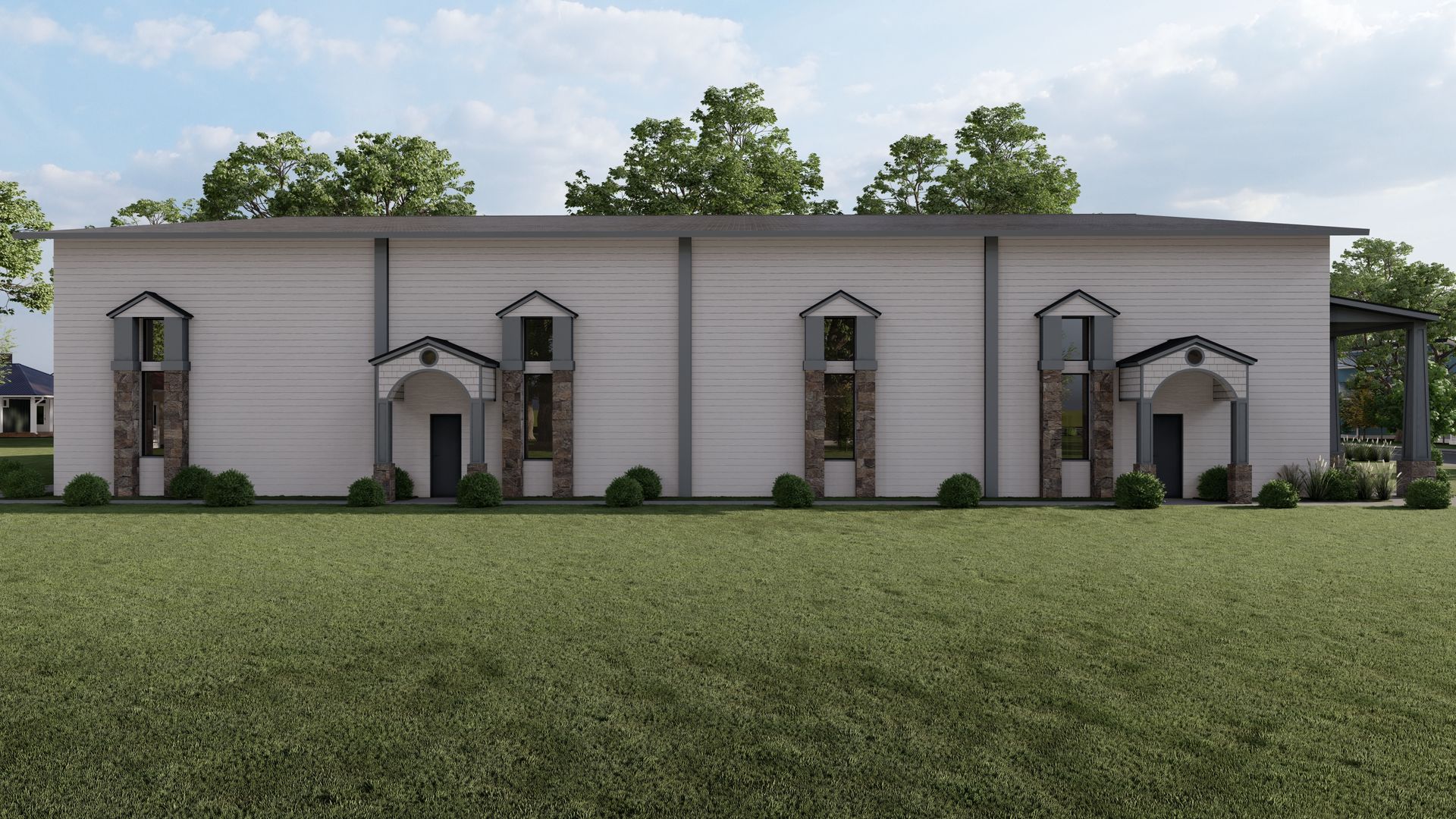 Exterior view of a white, rectangular building with stone accents. Green lawn and trees surround it.