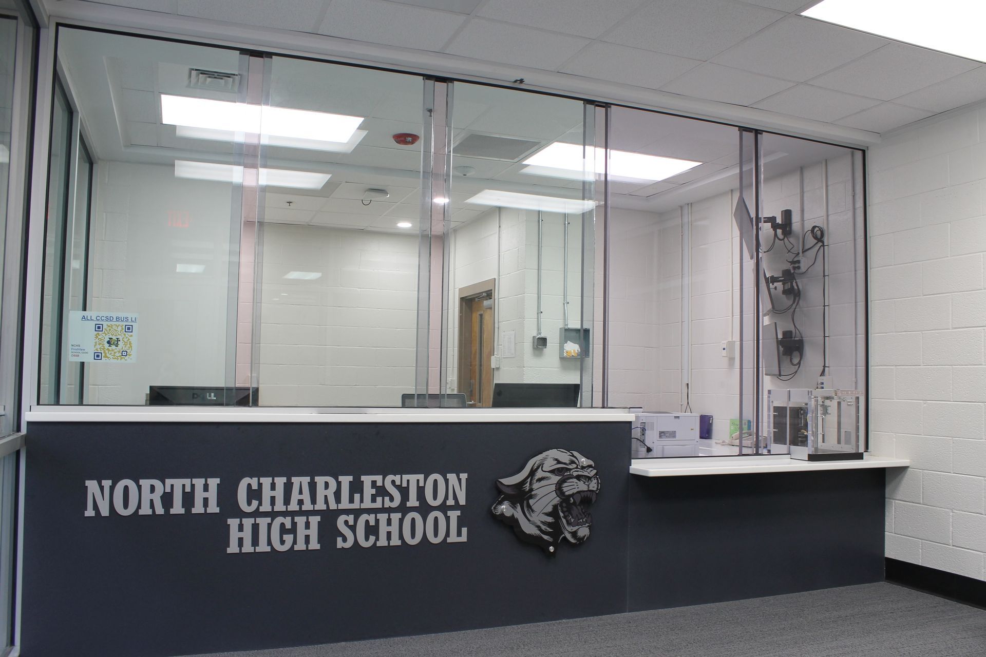 Reception desk at North Charleston High School with glass barriers.